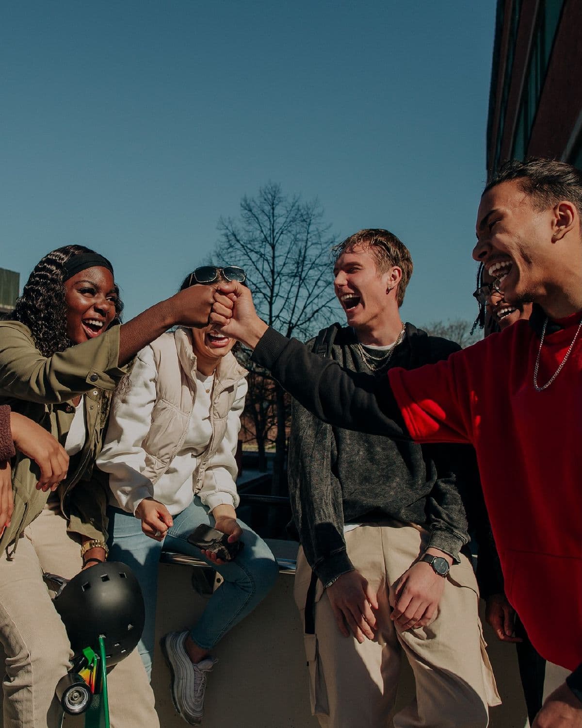A group of friends laughing together and connecting outdoors.